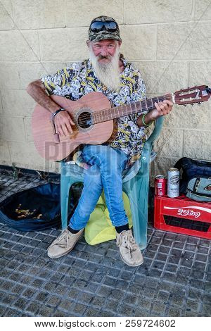 Torrevieja, Spain - Sept. 23 2018 :  Merlin Busking With Guitar Outside Carrefour Store