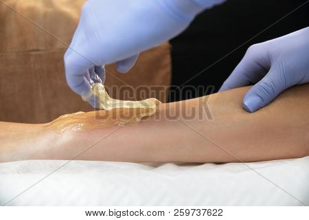 Beautician Removes Hair From A Woman's Hand.
