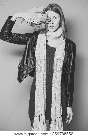 Fashion Model With Stylish Hair In Scarf. Beauty And Fashion. Girl With Orange Leaves On Orange Back