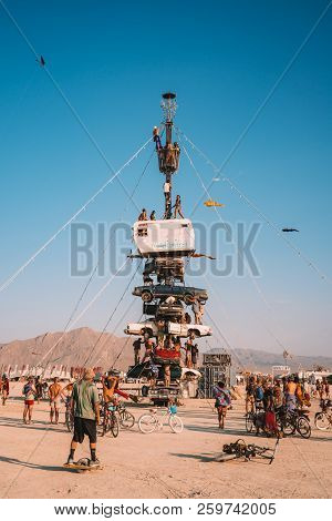 Guatemala - July 30, 2018. People Climbing Up The Huge Art Car Installation In The Middle Of A Deser
