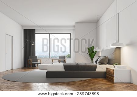 White Wall Minimalistic Bedroom Interior With A Wooden Floor, Round Carpet With Masterbed On It, Nig