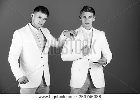 Man Holding Bank Card With Black Magnetic Stripe. Two Businessman Wearing White Jackets On Blue Back