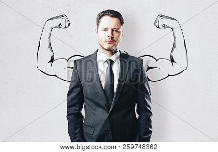 Portrait Of Attractive Young Businessman With Drawn Muscly Arms. Confidence And Power Concept