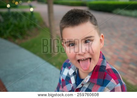 Boy Making Faces In The Evening Park. Childhood, Pampering Theme