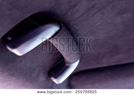 A Close-up View Of A Black Plastic Handle On The Ceiling In A Car In A Passenger Seat Pulled By A Bl