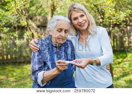 Happy Woman Expecting A Baby, Holding Pregnancy Test, Spending Time With Future Great-grandmother