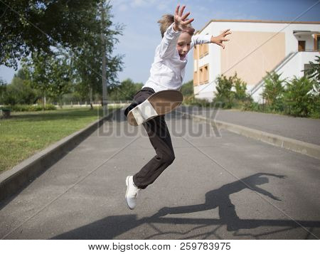 The Boy Jumps High. A Pupil Of Primary Classes On A Street Change