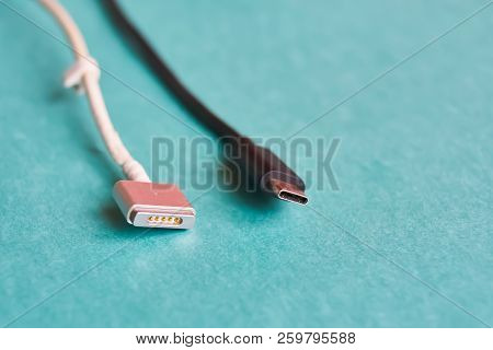 Black Usb Type C And White Magsafe Cable On Blue Background. Macro
