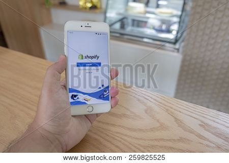 Chiang Mai / Thailand - September 22 2018 :a Man Sit In Cafe Holding Mobile With Shopify Screen