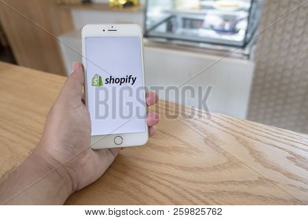 Chiang Mai / Thailand - September 22 2018 :a Man Sit In Cafe Holding Mobile With Shopify Screen