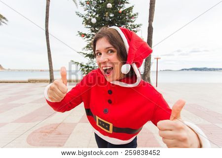 Christmas, Holidays, Humor And People Concept- Young Happy Woman In Christmas Suit At Summer Showing