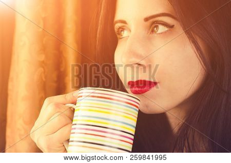 Young Woman With Thinking Sight Looks To The Window With A Cup Of Tea In Hands. Horizontal Close Up 