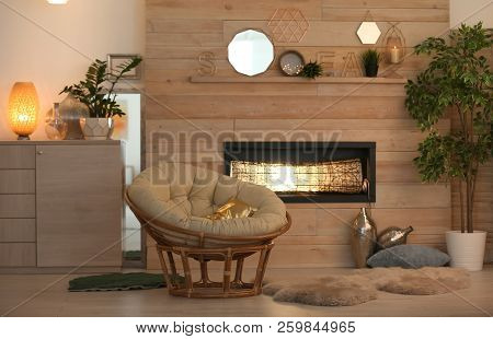 Cozy Living Room Interior With Comfortable Papasan Chair And Decorative Fireplace