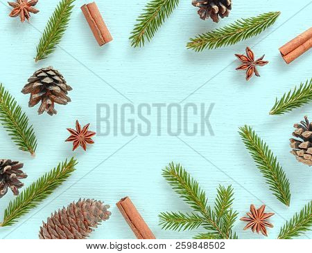 Christmas Frame Made Of Fir Tree Branches, Spices, Pine And Fir Cones On Turquoise Wooden Background