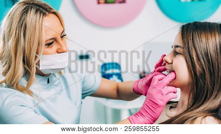 Orthodontist Checking Girl’s Dental Braces