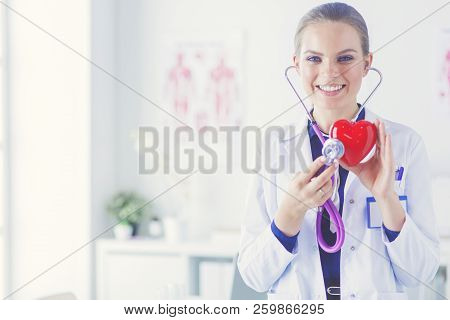 A Doctor With Stethoscope Examining Red Heart, Isolated On White Background