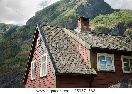 Low Angle View Of Beautiful Wooden House In Flam Village And Majestic Mountains, Aurlandsfjord Aurla