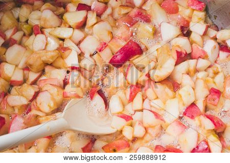 Cook Apple Jam And Stir With A White Plastic Spoon. Process Of Making Apple Jam Marmalade At Home