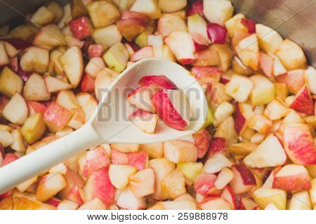 Cook Apple Jam And Stir With A White Plastic Spoon. Process Of Making Apple Jam Marmalade At Home