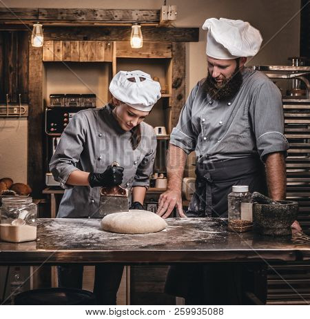 Chef Teaching His Assistant To Bake The Bread In A Bakery.