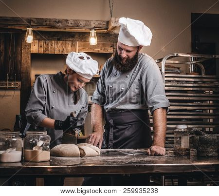 Chef Teaching His Assistant To Bake The Bread In A Bakery.