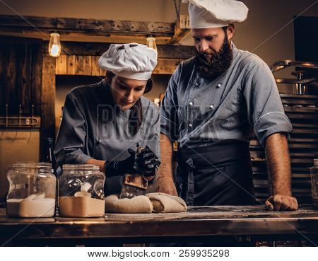 Chef Teaching His Assistant To Bake The Bread In A Bakery.