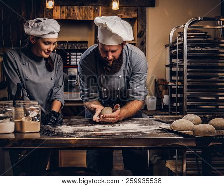 Chef Teaching His Assistant To Bake The Bread In A Bakery.