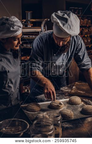 Cooking Master Class In Bakery. Chef With His Assistant Showing Ready Samples Of Baking Test In Kitc