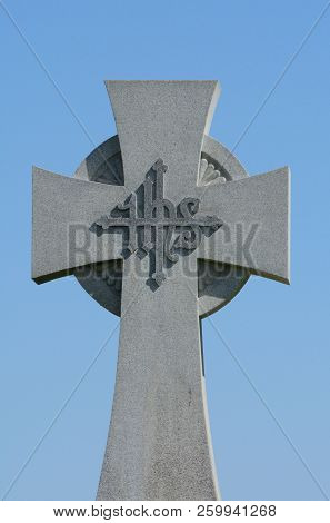 Granite Celtic Cross With Christogram Ihs On Engraved Cross In Center Against Blue Sky