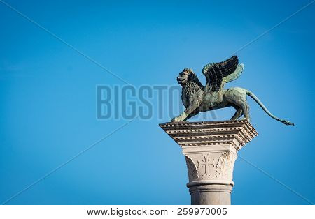 Venice's Symbol, The Winged Lion Statue Against A Blue Sky.