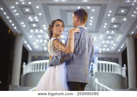 The Bride And Groom Stand On The Beautiful Porch Of The Hotel At Night