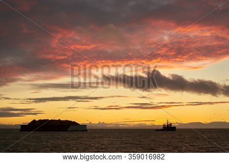 Georgia Strait Steveston Tugboat Sunset. A Tugboat Towing A Barge Down The Fraser River Into The Str