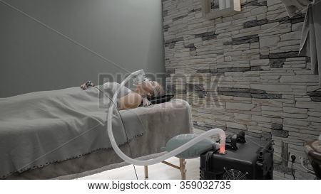 Girl Lies On Bed With Artificial Respiration Mask