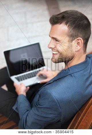 Ung mand sidder med sin Laptop