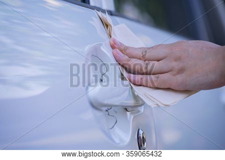 Asian Women Spry Soap And Clean Car Door Handle With Napkin.