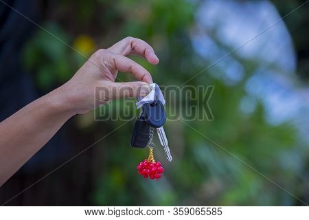 Asian Women Holding Dirty Car Keys With Napkin.