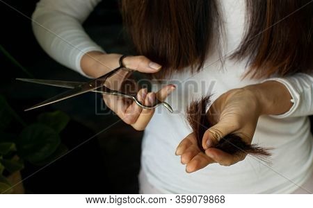 Woman Cutting Own Hair. Depressed Woman Cutting Her Hair.