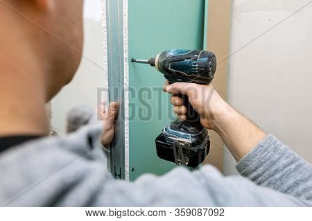 Man Installing Moisture Resistant Drywall Sheets For Bathroom Bulkhead