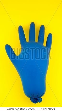 Inflated Medical Blue Gloves On A Yellow Background. The Concept Is A Blown Pandemic Of 2020.