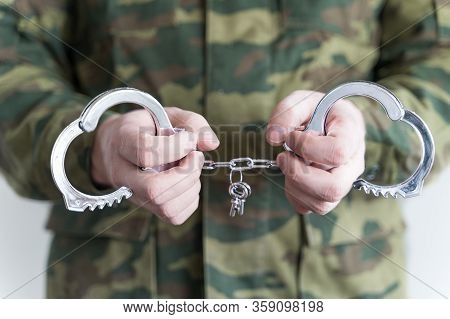 Police Officer With Handcuffs In Khaki Colored Uniform Stops And Arrest Criminal On The Street For V