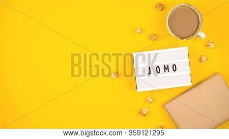 Abbreviation Word Jomo Written On A Decorative Board On A Bright Yellow Background. The Concept Of R
