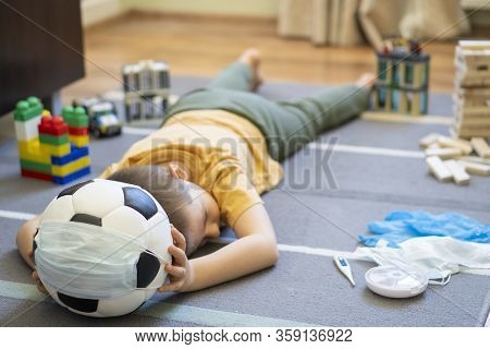 Soccer Ball In A Medical Mask. Activities At Home With Your Children During Home Coronavirus Quarant