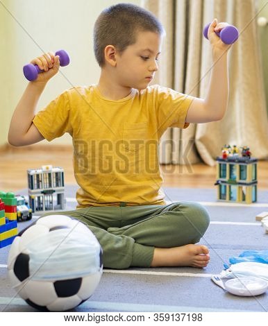 Soccer Ball In A Medical Mask. Activities At Home With Your Children During Home Coronavirus Quarant