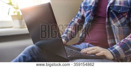 Man Wearing Checkered Shirt With Laptop Works At Home. Banner. Remote Work. Online Education. Quaran