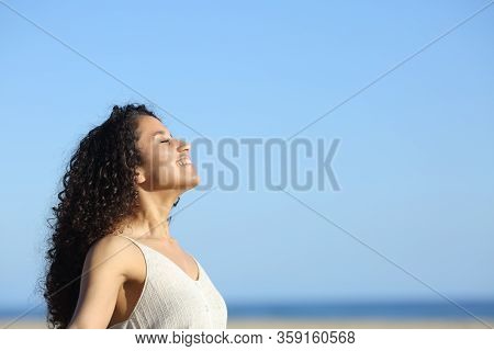 Side View Portrait Of A Relaxed Young Woman Breating And Enjoying Sun On The Beach In Summer