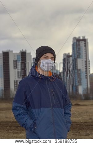 Teen Wearing A Medical Mask Against The Background Of A City Against Quarantine