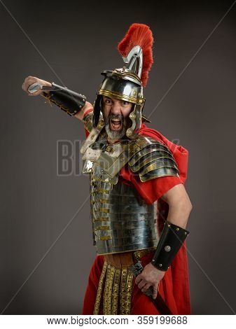 Roman soldier holding his sword ready to atack isoladed on a dark background