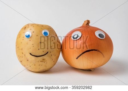 Positive Potato And A Sad Napiform Onion With Googly Eyes On A White Background. Pessimist And Optim