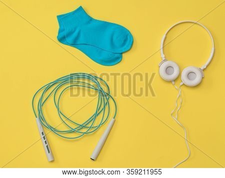 Jump Rope, Headphones And Sports Socks On A Yellow Background. The Color Trend. The Concept Of Music