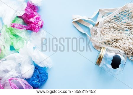 Many Disposable Plastic Bags Vs Reusable Cotton Bag And Glass Jar On A Blue Background. Zero Waste S